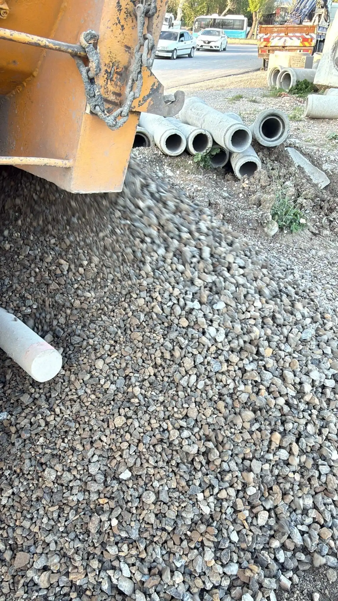 Boru hattı işinde damperden dökülen mıcır, yanında beton borular