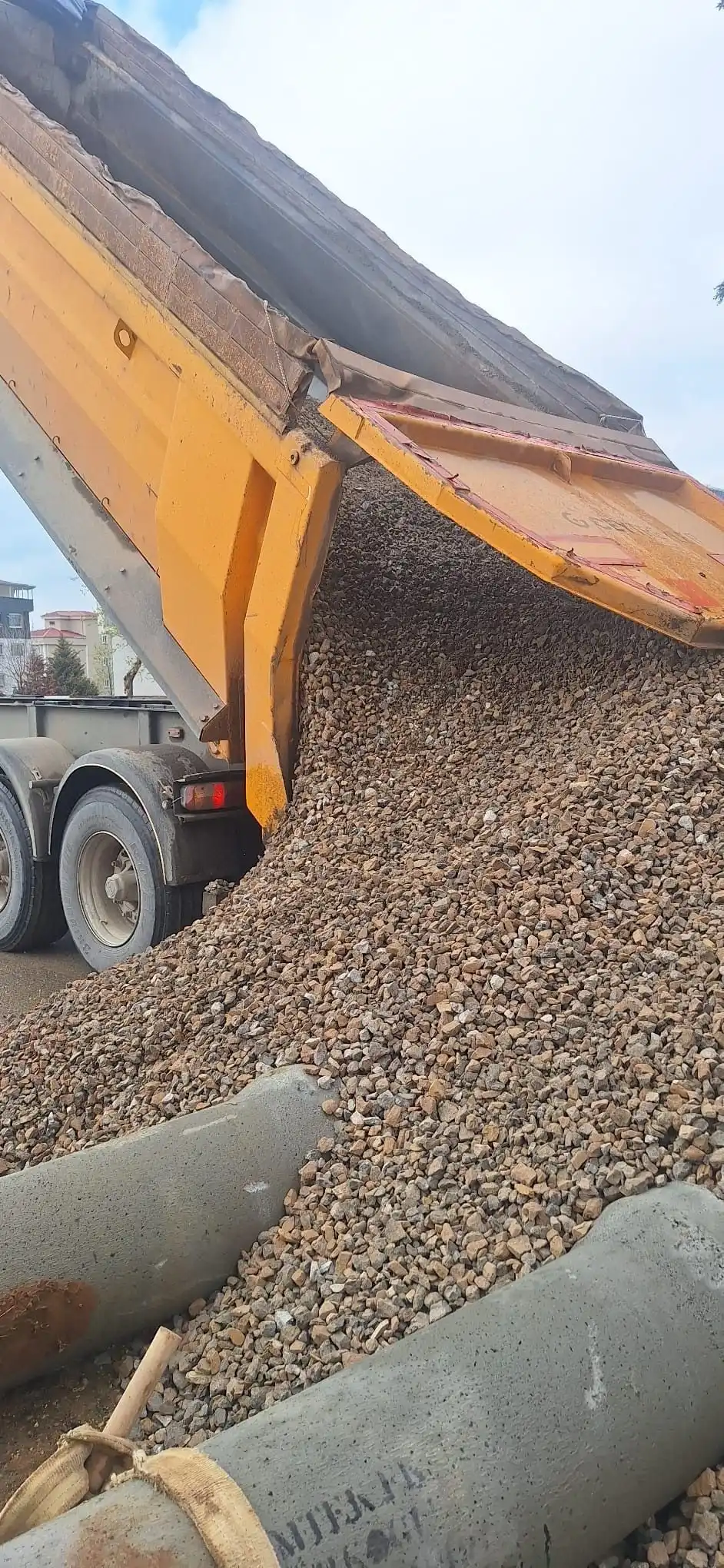 Damperli dorseden altyapı çalışmasındaki boruların yanına mıcır boşaltılırken