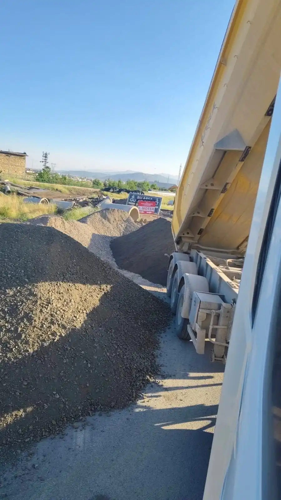 Damperli dorsenin yanında yol kenarına boşaltılmış malzeme yığınları