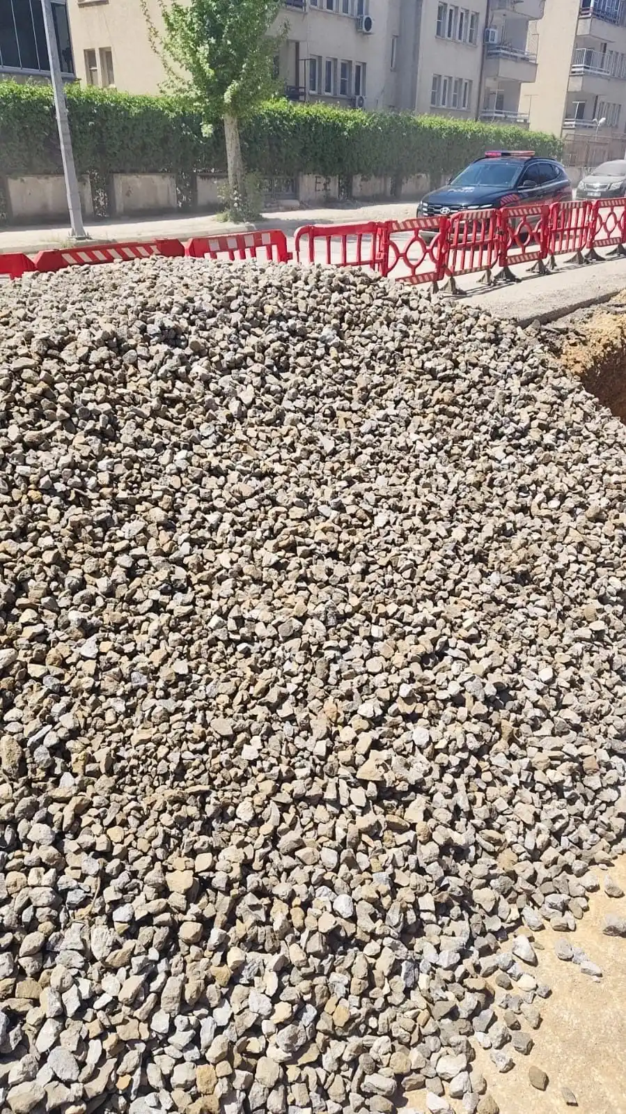 Şehir içinde bariyerlerle çevrili şantiyeye teslim edilmiş mıcır yığını
