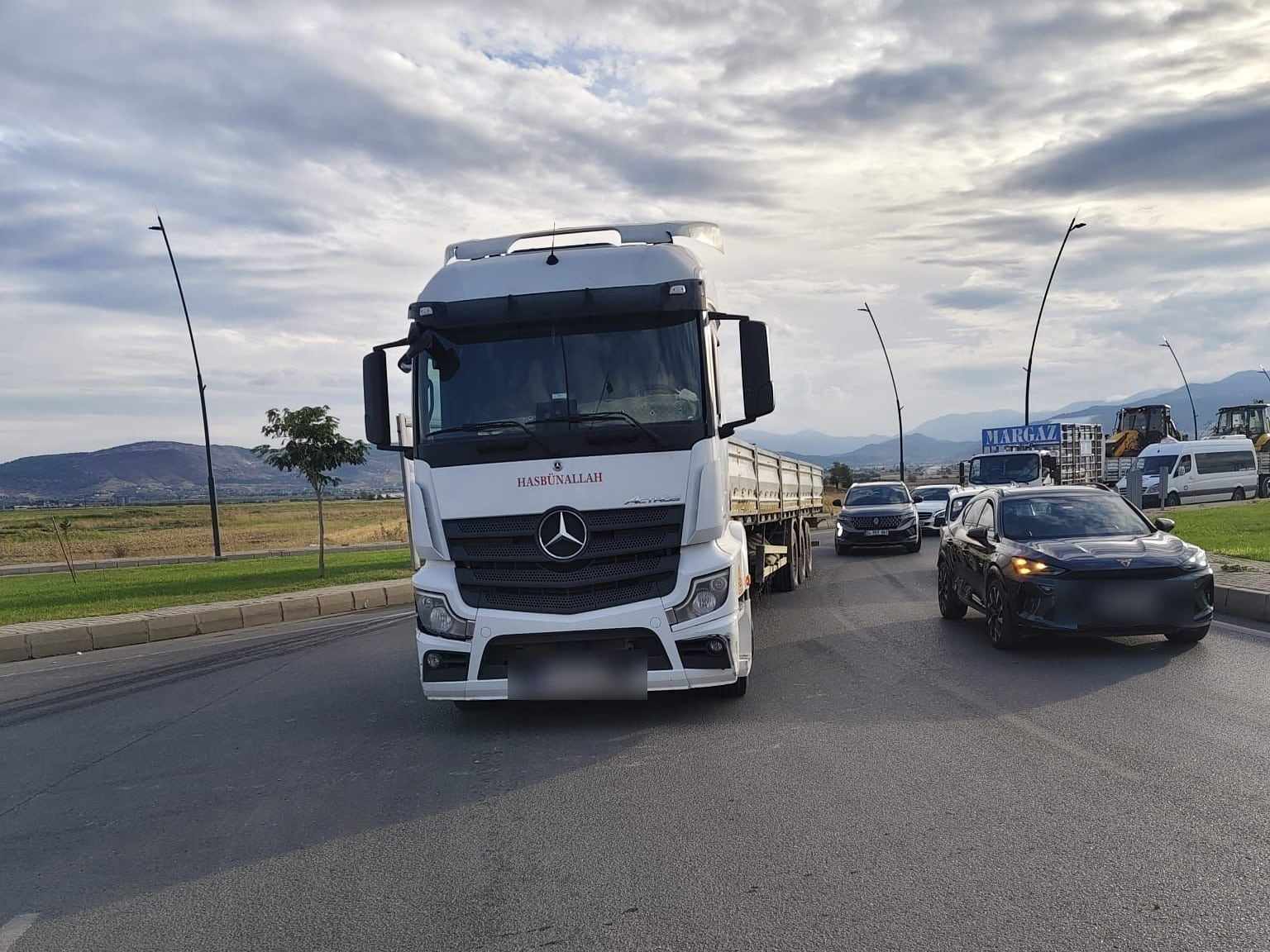 Kahramanmaraş'ta yolda ilerleyen, ön camında KAYALAR yazan beyaz Mercedes çekici ve açık kasa dorse